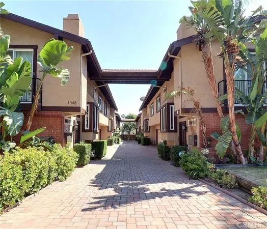 a view of a white house with a small yard and plants