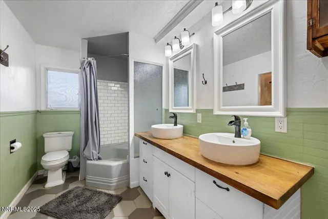 a bathroom with a granite countertop toilet sink and mirror