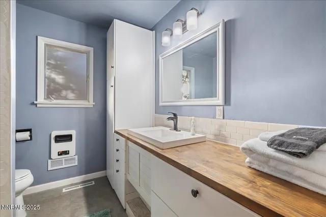 a en suite bathroom with a granite countertop sink and a mirror
