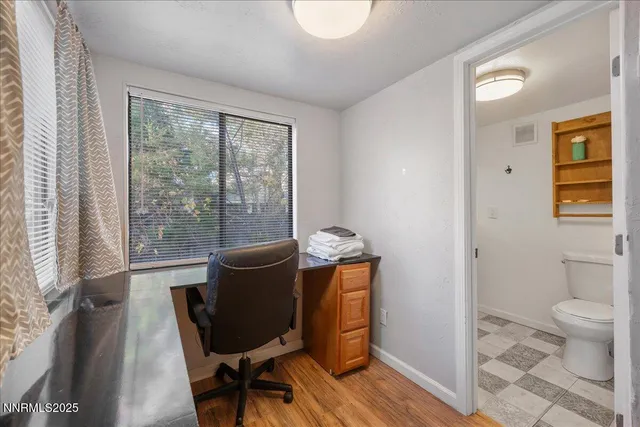 a view of a workspace with furniture and a window