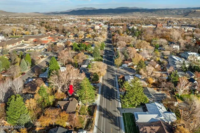 an aerial view of residential houses with outdoor space and trees