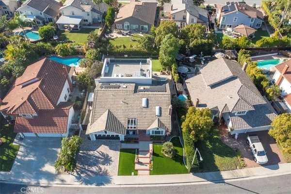 an aerial view of residential houses with outdoor space and parking
