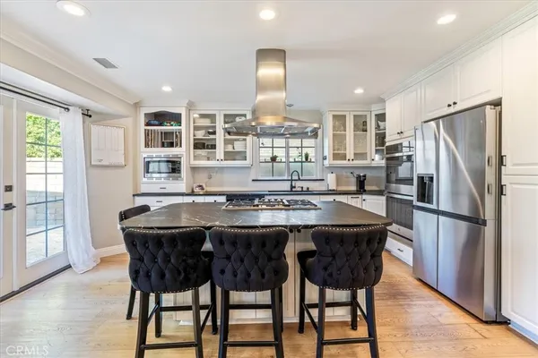 a kitchen with kitchen island granite countertop wooden cabinets and stainless steel appliances