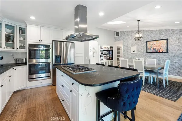 a kitchen that has a table chairs and wooden floor