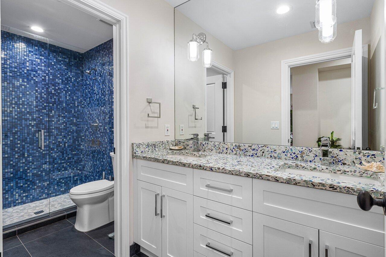 963 Eve Street Delray Beach, FL 33483 - Photo 29 of 83 a bathroom with a granite countertop sink a toilet and a mirror