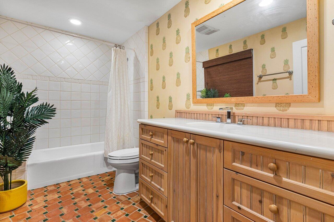963 Eve Street Delray Beach, FL 33483 - Photo 45 of 83 a bathroom with a sink a toilet a mirror and shower
