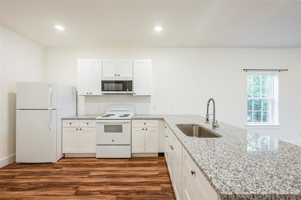 3523 Herrling Street Dallas, TX 75210 - Photo 7 of 14 Kitchen featuring white appliances, a peninsula, dark wood-type flooring, white cabinetry, and recessed lighting