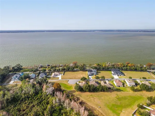 an aerial view of ocean and residential houses with outdoor space