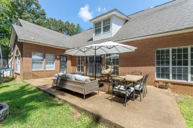 a backyard of a house with table and chairs