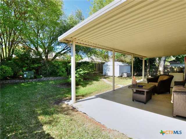 a patio with table and chairs and garden