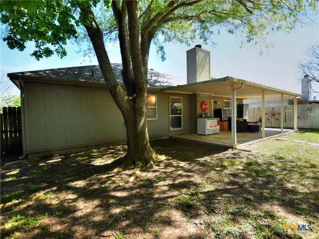 a tree in front of a white house