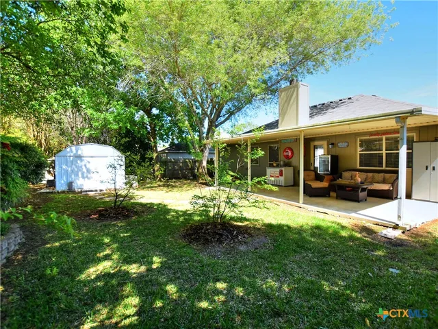 a view of a house with backyard and sitting area