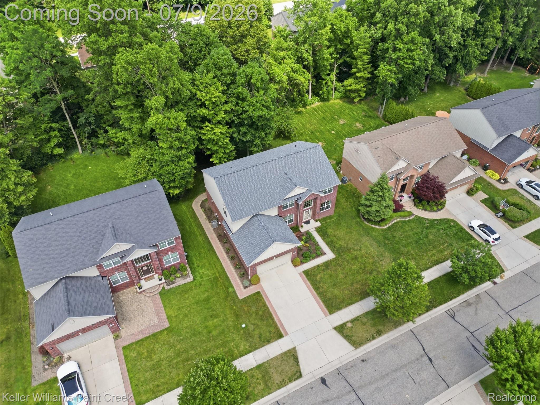 846 Monterey Ln. Rochester, MI 48307 - Photo 43 of 52 Brick exterior residence featuring a gabled roof, mature landscaping, paved driveway, and established sidewalks
