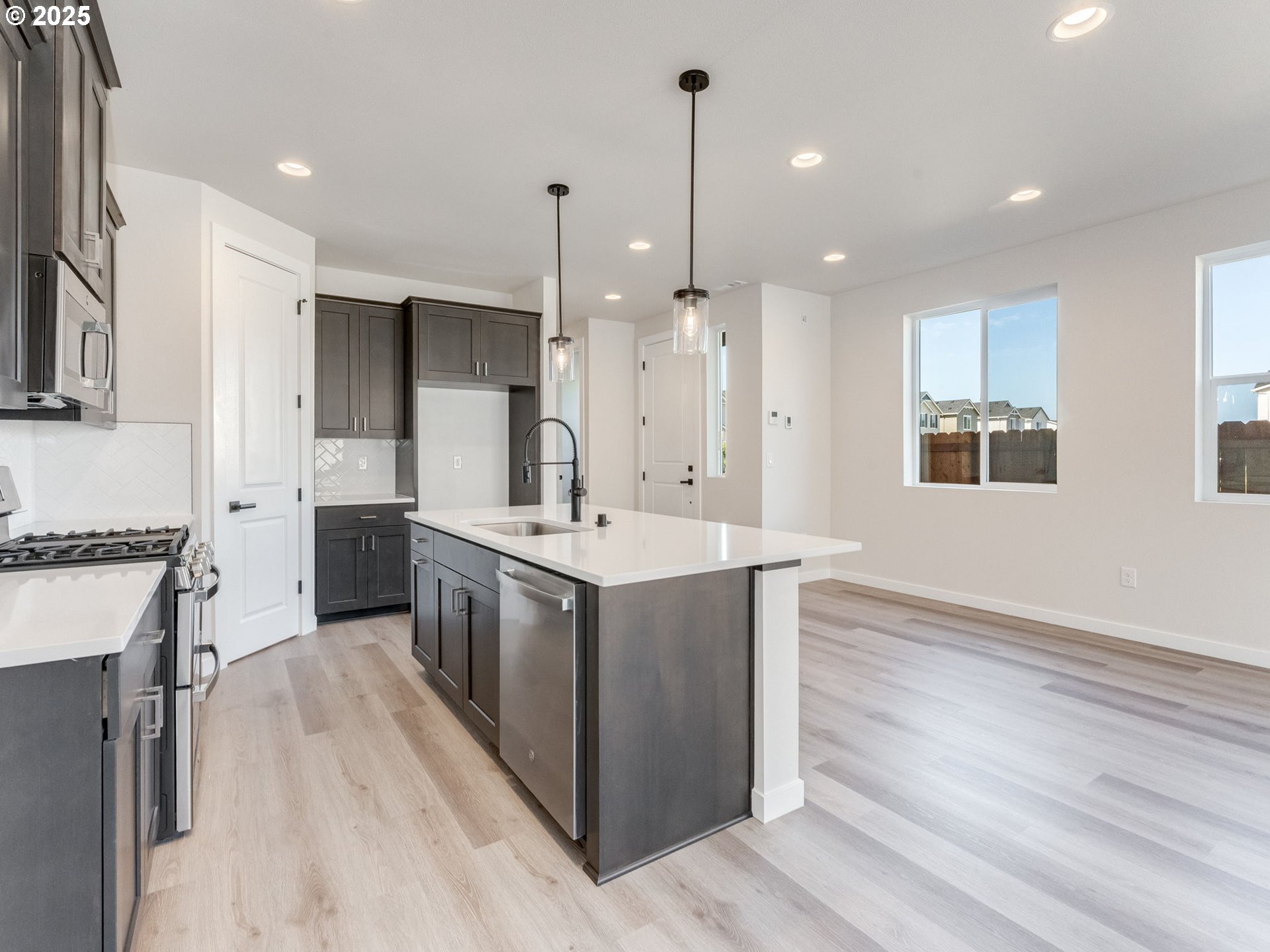 744 Northwest 178th Street Ridgefield, WA 98642 - Photo 5 of 25 a large kitchen with stainless steel appliances kitchen island a large counter top a sink a stove and a refrigerator