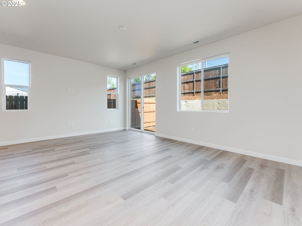 744 Northwest 178th Street Ridgefield, WA 98642 - Photo 7 of 25 an empty room with wooden floor and windows