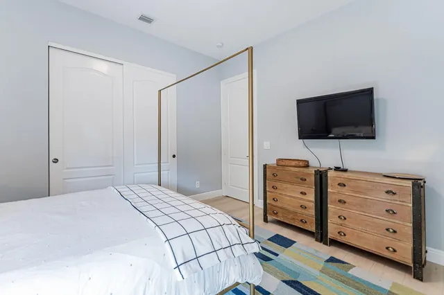 a bedroom with a bed and a flat tv screen in it