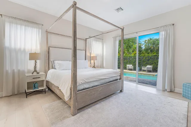 a large bed sitting in a room next to a window