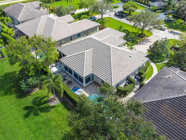 an aerial view of a house with a yard and large trees