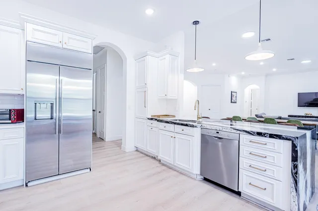 a large kitchen with granite countertop a stove a sink and a refrigerator