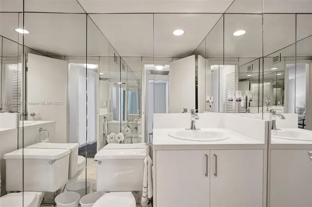 a bathroom with a sink and mirror with toilet