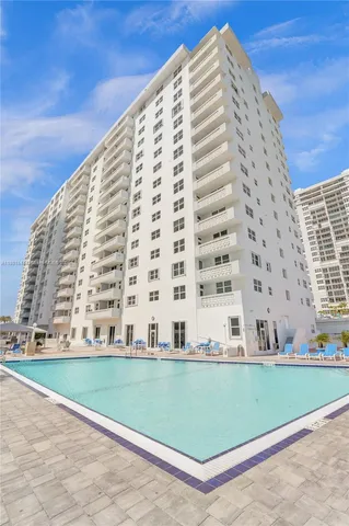 a view of a tall building next to a yard