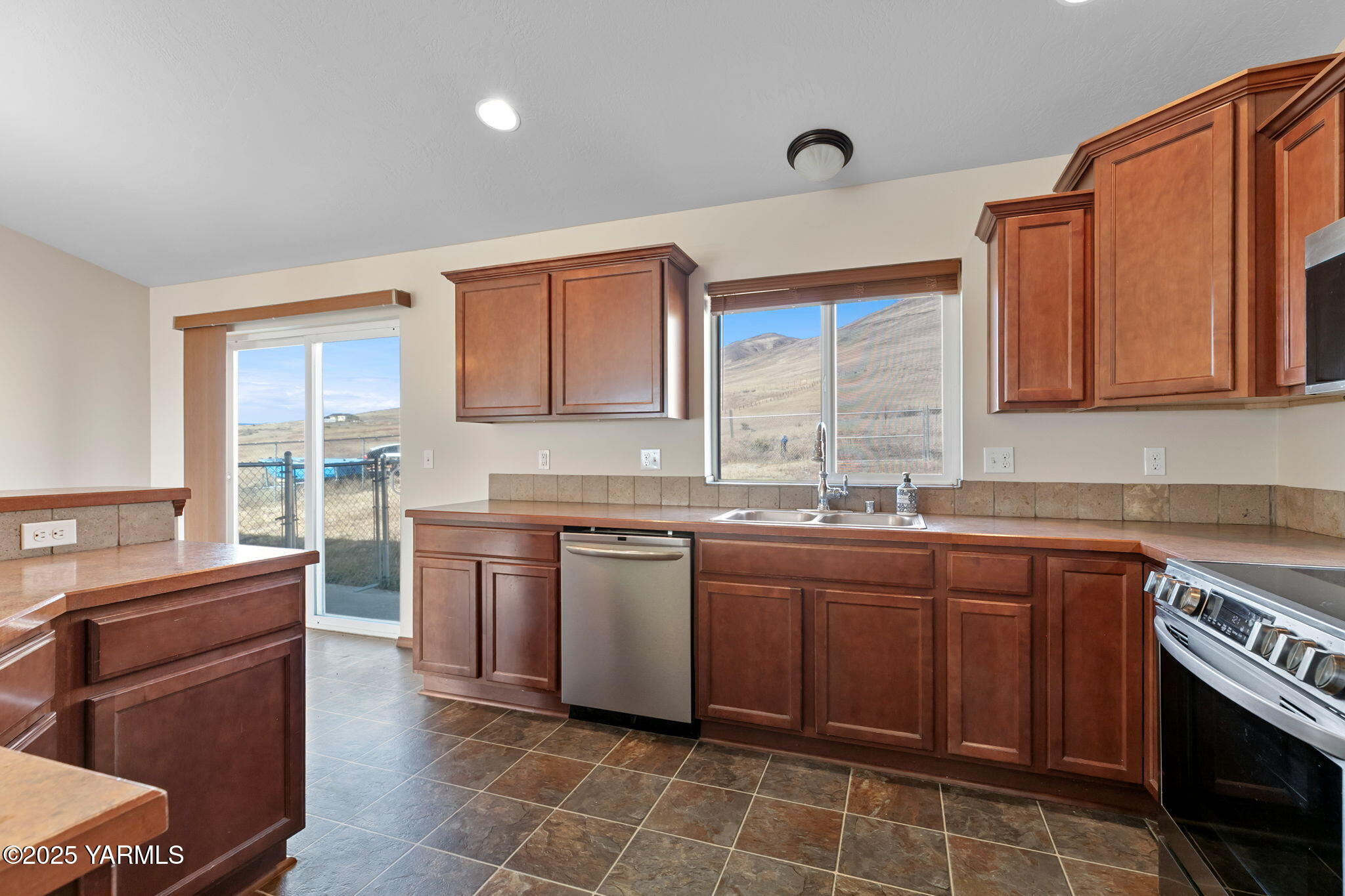 1101 Elk Ridge Lane Selah, WA 98942 - Photo 12 of 28 a kitchen with stainless steel appliances granite countertop a sink counter space cabinets and a large window