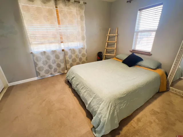 a bedroom with a bed and next to a window