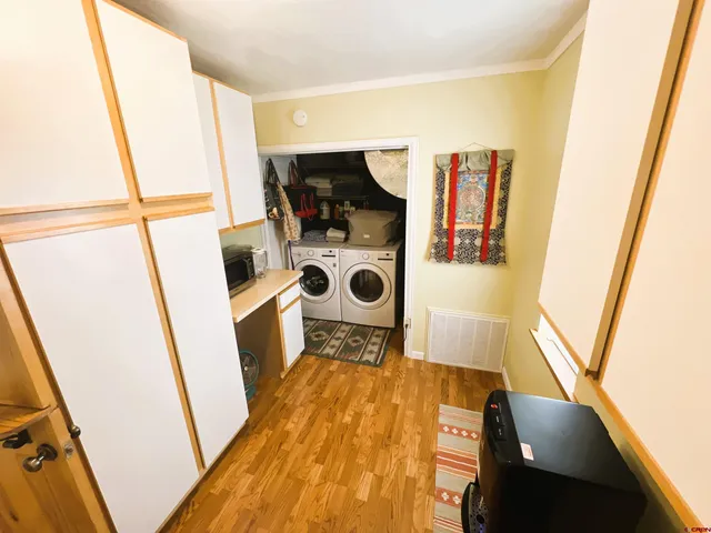 a view of walk in closet with clothes and door