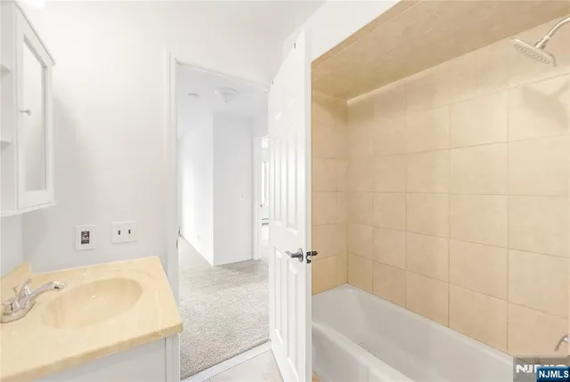 a bathroom with a tub a sink and mirror