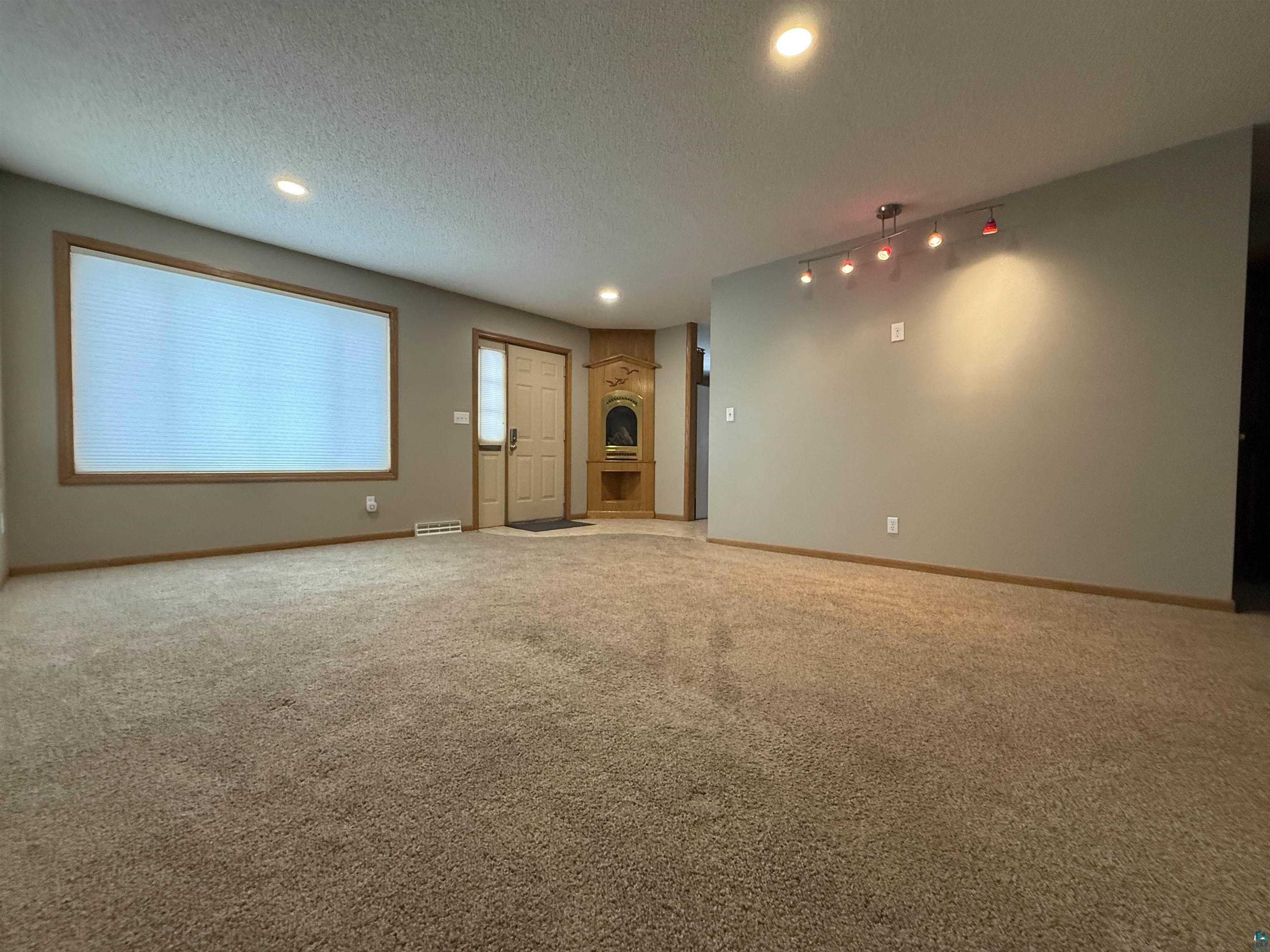 1321 South 13th Street Virginia, MN 55792 - Photo 10 of 33 Unfurnished living room with a textured ceiling, light colored carpet, and recessed lighting