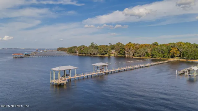 an aerial view of a house with wooden floor and lake view