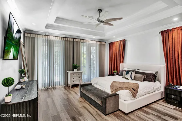 a bedroom with a bed lamps and wooden floor