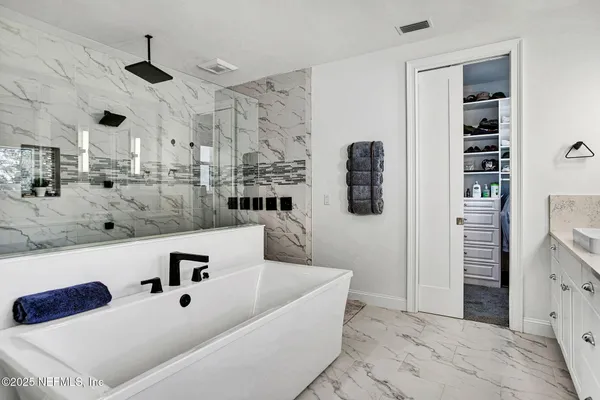 a kitchen with stainless steel appliances kitchen island granite countertop a refrigerator and a sink