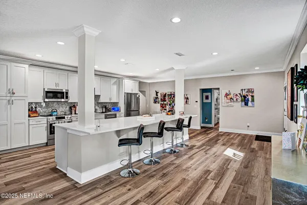 a living room with stainless steel appliances furniture and a view of kitchen