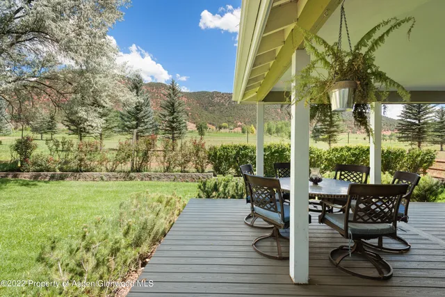 a view of a chairs and table in patio with wooden fence