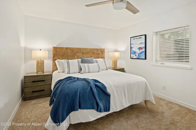 a bedroom with a bed and painting on the wall