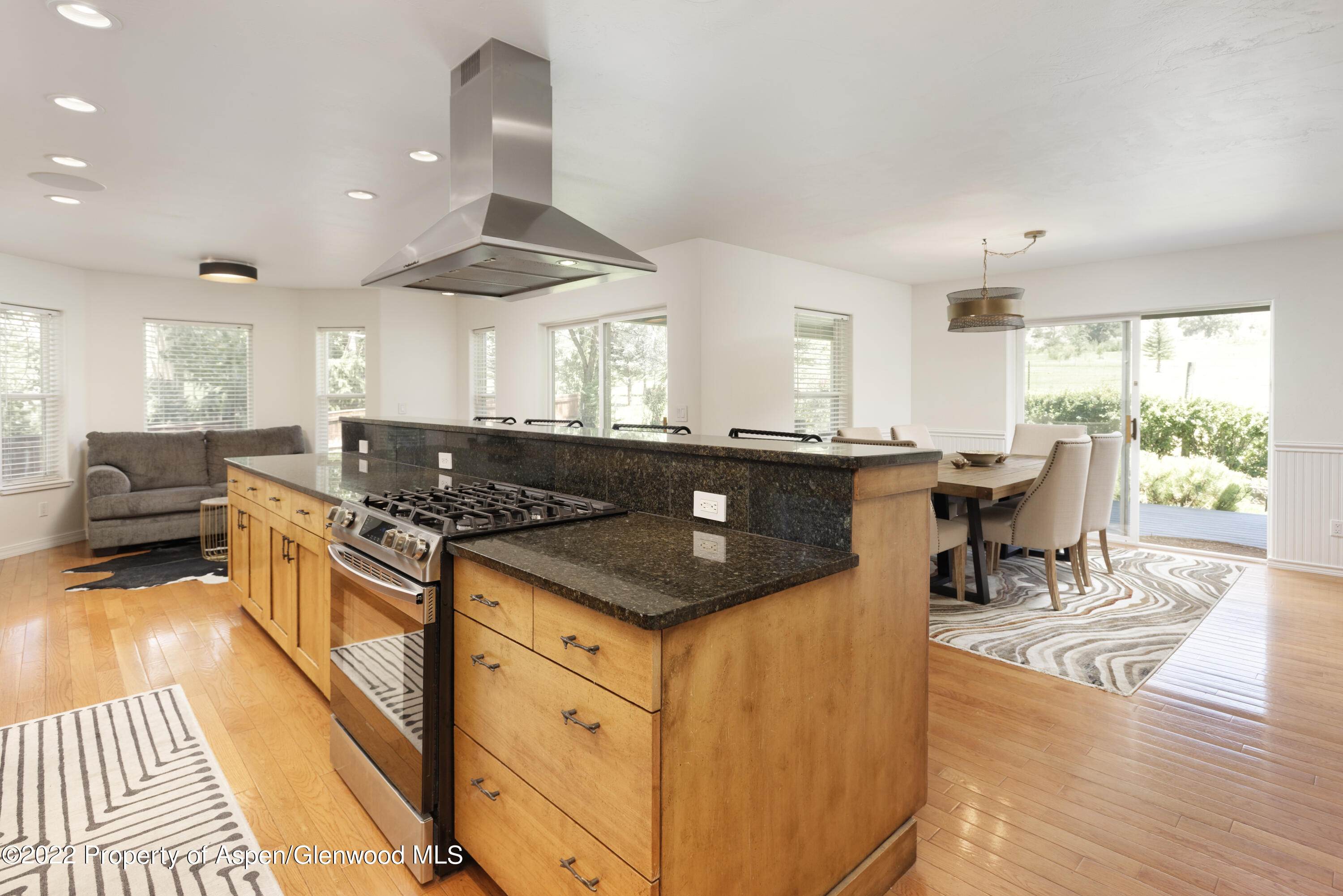 965 Lupine Circle Basalt, CO 81621 - Photo 10 of 31 a kitchen with stainless steel appliances granite countertop a stove top oven a dining table and chairs with wooden floor
