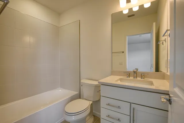 a bathroom with a granite countertop toilet sink and mirror