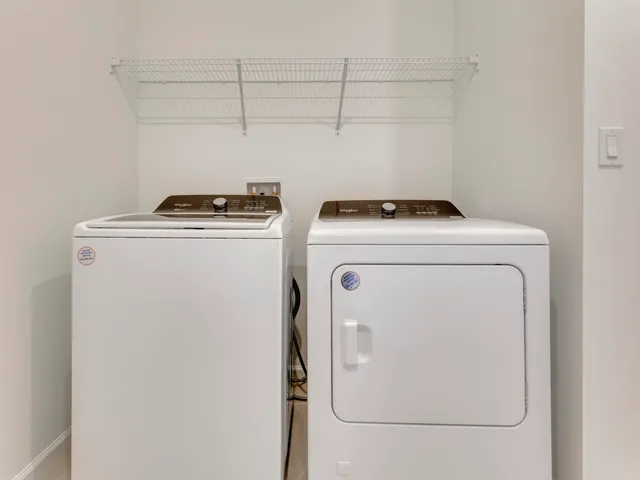 a view of a lake with lawn chairs and large tree