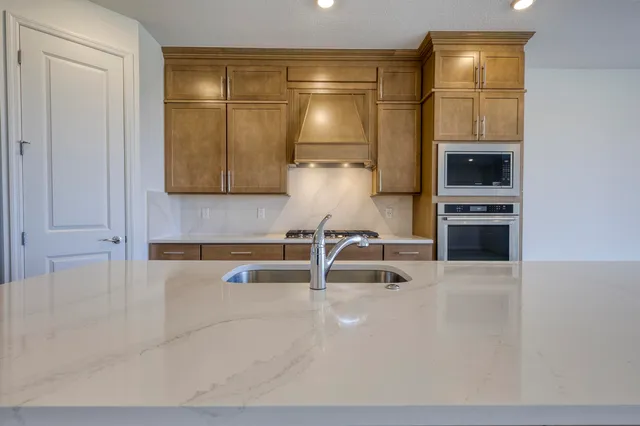 a large kitchen with stainless steel appliances a large counter top