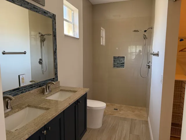 a bathroom with a granite countertop sink toilet and shower
