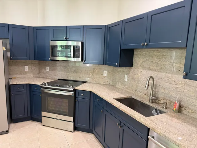 a kitchen with stainless steel appliances granite countertop a refrigerator and a sink