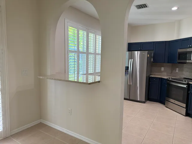 a view of an empty room with window and chandelier