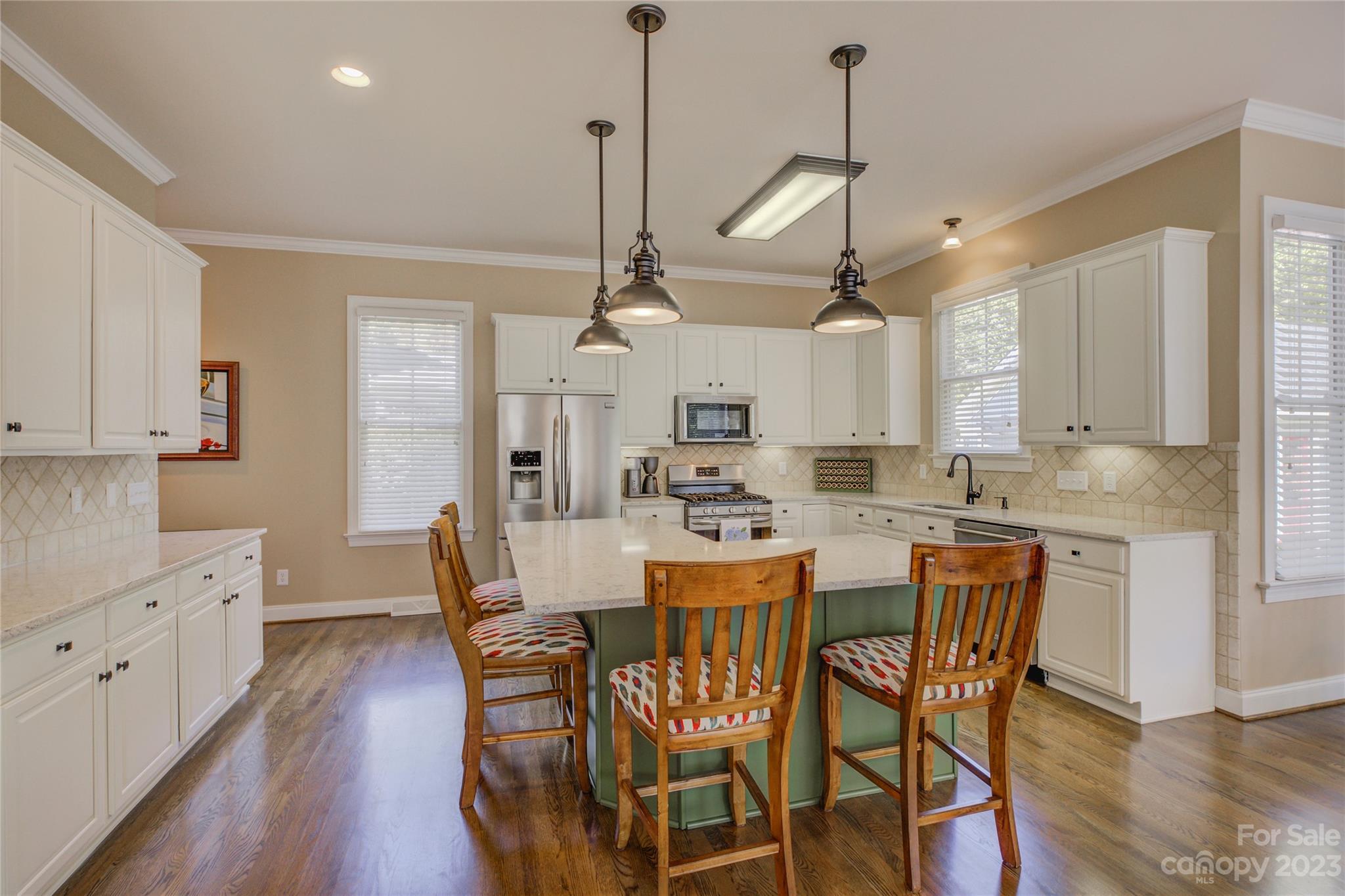 7124 Michael Scott Crossing Fort Mill, SC 29708 - Photo 12 of 48 a kitchen with stainless steel appliances a kitchen island a stove a table and chairs
