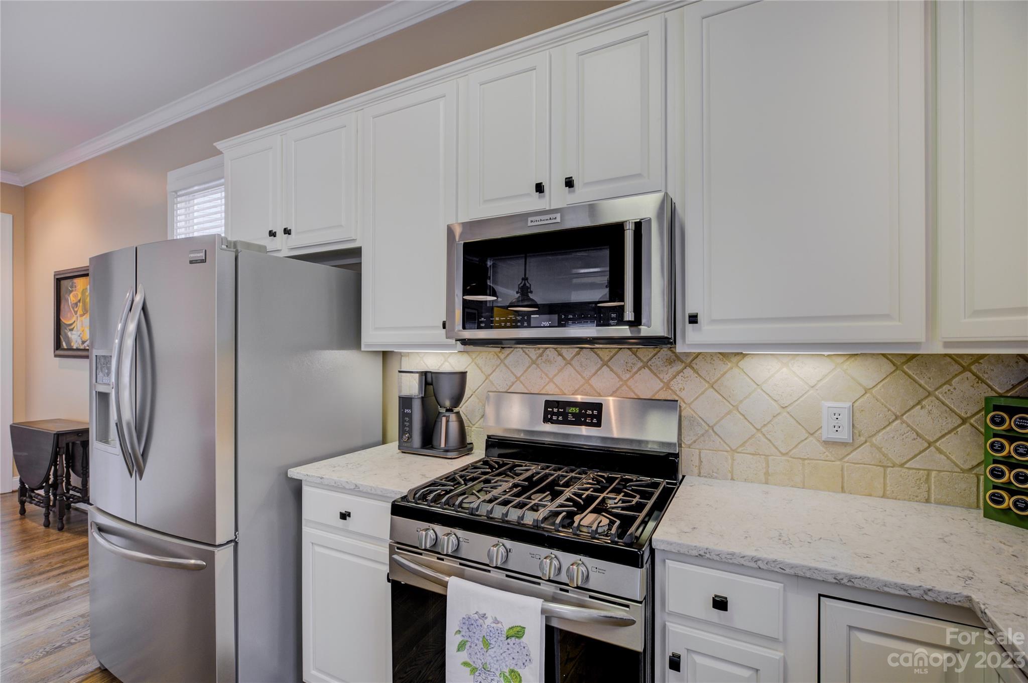 7124 Michael Scott Crossing Fort Mill, SC 29708 - Photo 14 of 48 a kitchen with stainless steel appliances white cabinets and a stove top oven