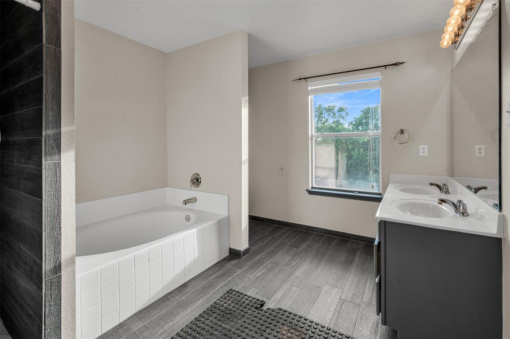 9017 Graywolf Ridge Trail Fort Worth, TX 76244 - Photo 23 of 27 Bathroom featuring dual bowl vanity and tiled tub