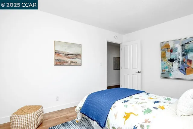 a bedroom with a bed and a painting on the wall