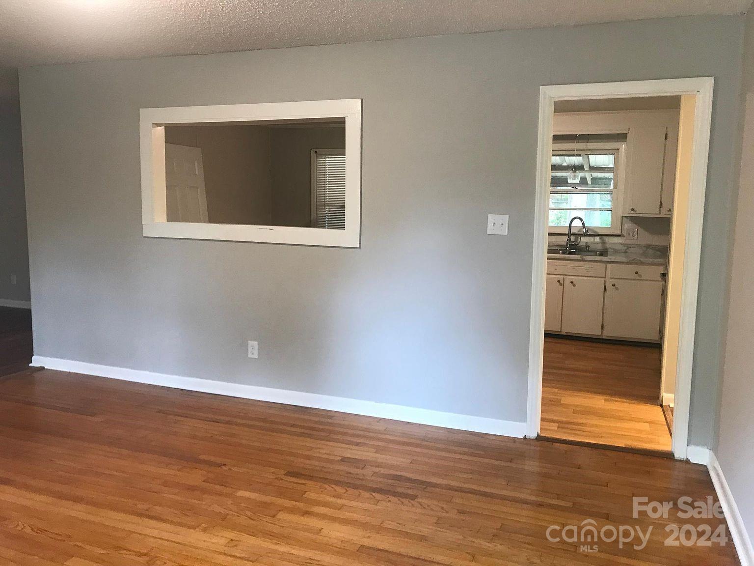 1300 Stallings Road Matthews, NC 28104 - Photo 3 of 19 a view of a hallway with wooden floor and a kitchen