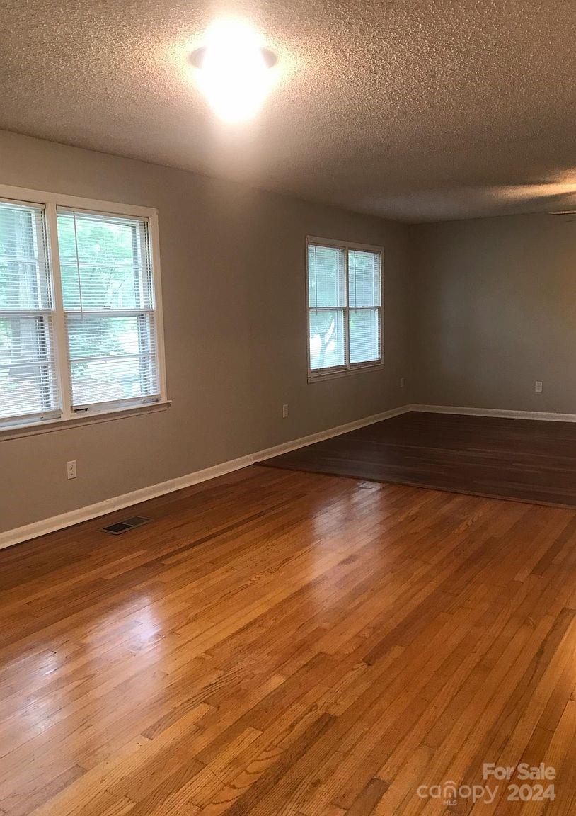 1300 Stallings Road Matthews, NC 28104 - Photo 10 of 19 an empty room with wooden floor and windows