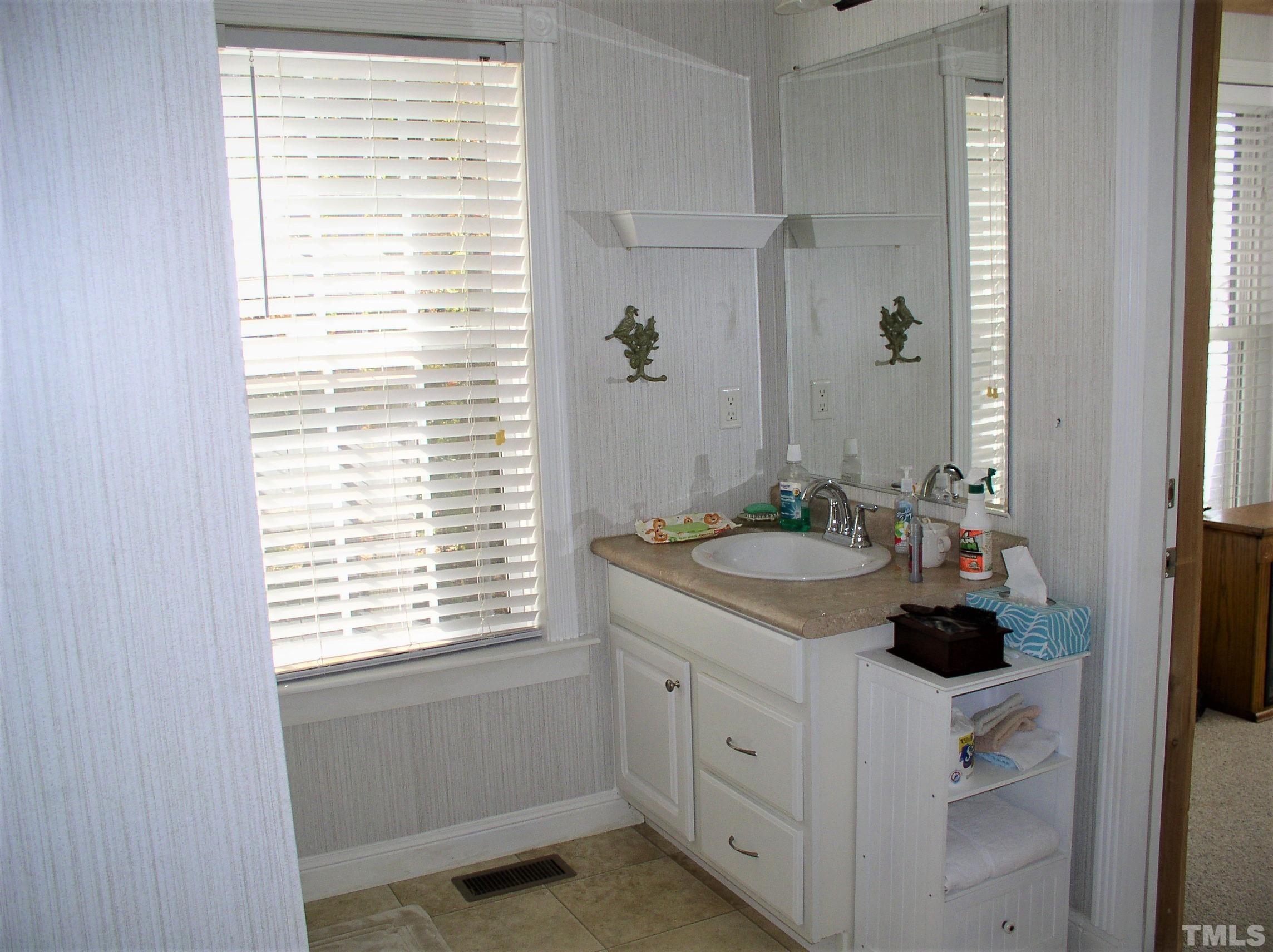 64 Fish Trail Bracey, VA 23919 - Photo 19 of 39 a bathroom with a granite countertop sink and a window